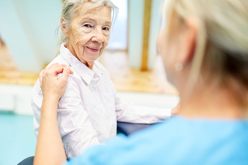 Photo of elderly patient being helped by a nurse