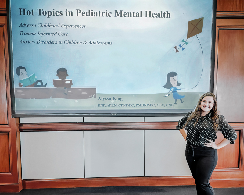 Photo of woman presenting a presentation at a symposium