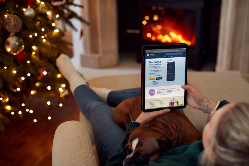 Photo of woman sitting on couch with ipad looking at nursing ceus