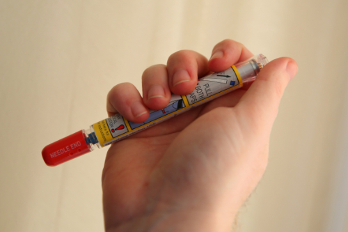 photo of individual holding epipen