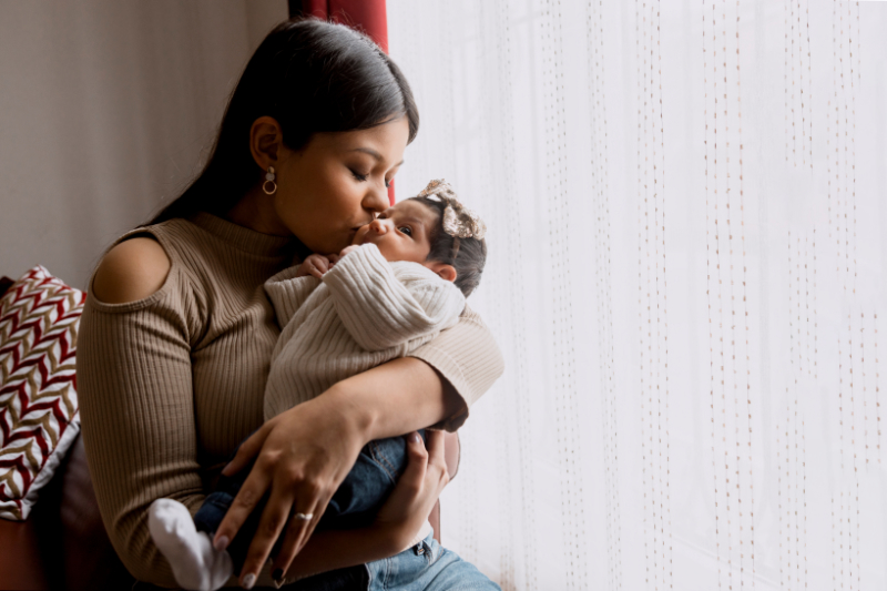 photo of woman holding infant