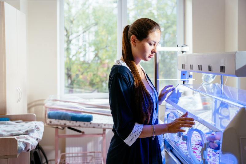 photo of mother looking at baby in incubator 