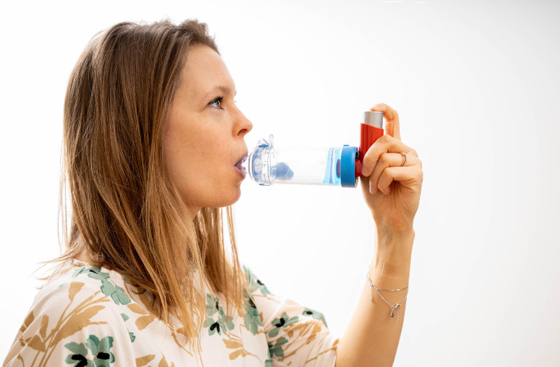 photo of lady using inhaler with spacer