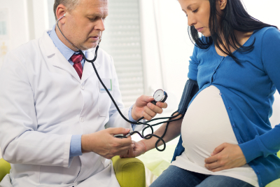 photo of pregnant woman and doctor doing exam