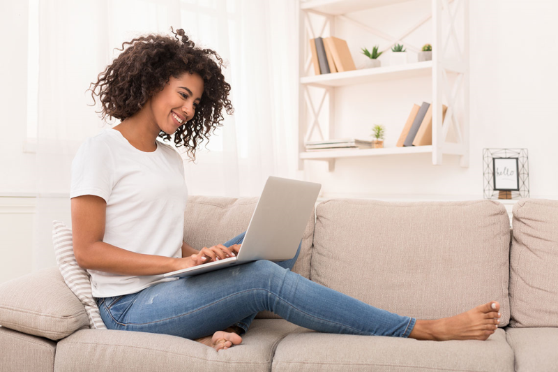 Photo of woman sitting on the couch with laptop