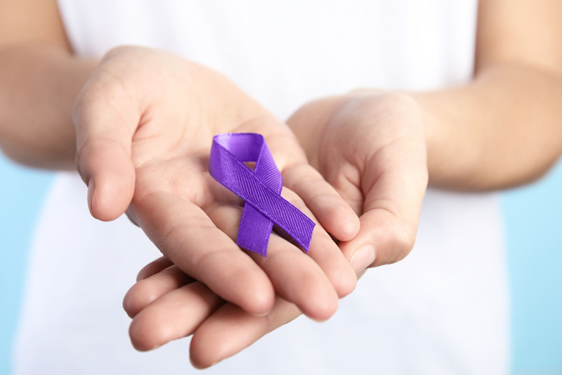 woman holding purple ribbon representing domestic violence awareness