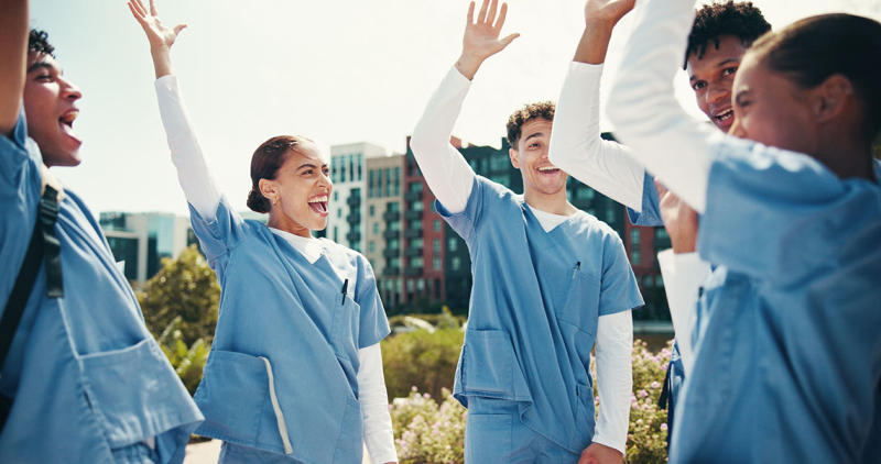 Photo of nursing students celebrating with their hands in the air