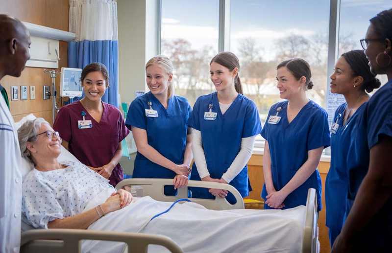 Photo of nursing students standing around patient in hospital bed